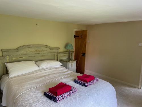 a bedroom with a bed with two red pillows on it at Bartley Mill Farmhouse in Wadhurst