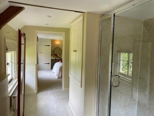 a bathroom with a walk in shower and a glass shower stall at Bartley Mill Farmhouse in Wadhurst