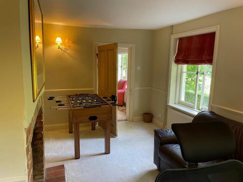 a living room with a game table and a couch at Bartley Mill Farmhouse in Wadhurst