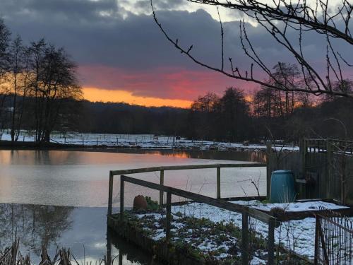 a sunset over a river with snow on the water at Bartley Mill Farmhouse in Wadhurst
