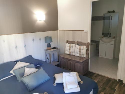 ein Schlafzimmer mit einem blauen Bett mit Kissen und einem Waschbecken in der Unterkunft Les Tamaris in Campsegret