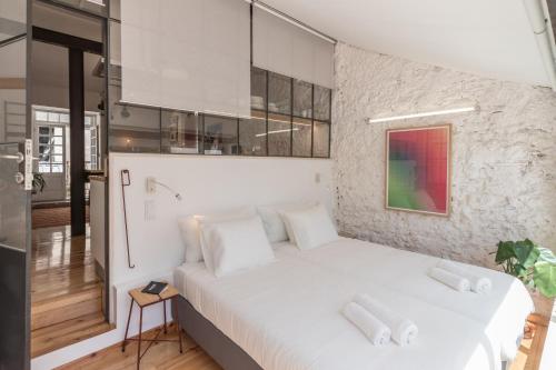 リスボンにあるApartamento com varanda, muito central, TTL333の石壁の客室で、白い大型ベッド1台が備わります。
