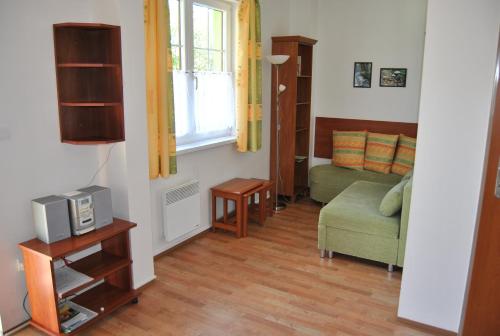 マラー・モラーヴカにあるHorské apartmány Jeseníkyのリビングルーム(テレビ、ソファ付)