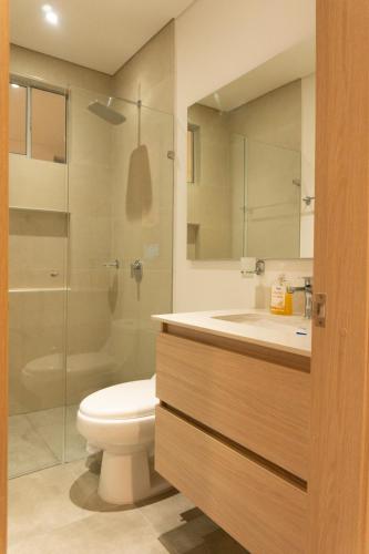 a bathroom with a toilet and a sink and a shower at confortable apartasuite en la playa in Gaira