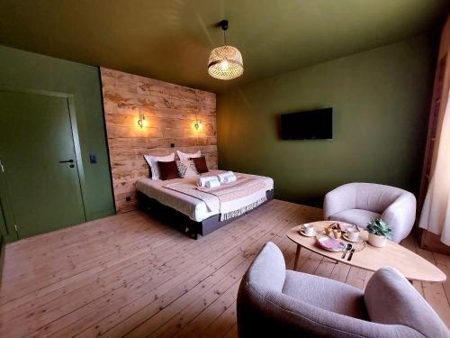 a bedroom with a bed and two chairs and a table at MyDeer - Deluxe rooms & shared kitchen in Malmedy
