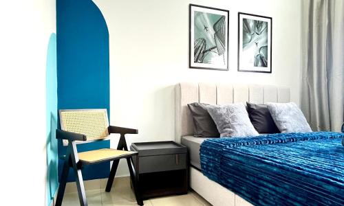 a bedroom with a blue bed and a chair at Alanis Suite With Netflix @ KLIA Sepang in Sepang