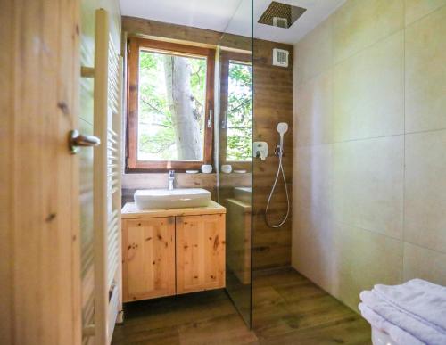 a bathroom with a sink and a glass shower at Na Skaluc - Country estate & Glamping in Trobni Dol