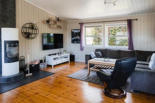 ein Wohnzimmer mit einem Sofa und einem Tisch in der Unterkunft Leilighet med flott uteplass in Ulefoss