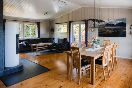 a dining room and living room with a table and chairs at Leilighet med flott uteplass in Ulefoss