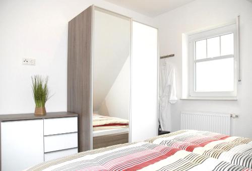 a bedroom with a mirror and a bed at Mien Dröm in Norddeich