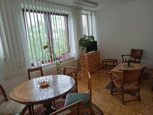un soggiorno con tavolo, sedie e finestre di Ferienwohnung Veljanovski a Blaufelden