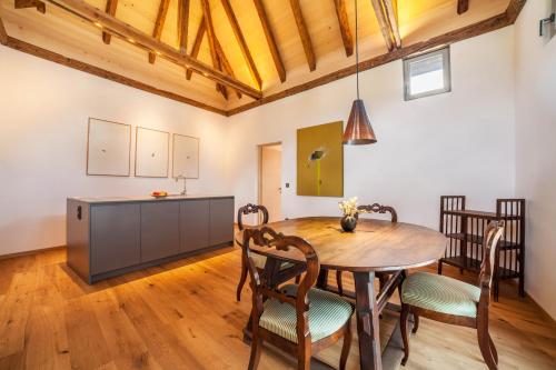 a kitchen and dining room with a wooden table and chairs at Ansitz Layshof Apartment Turm in Merano