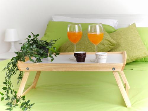 two wine glasses on a tray on a bed at [RHO FIERA] Apartment near the Metro in Pero