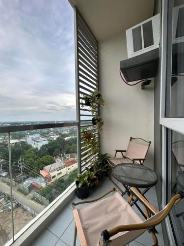 a balcony with two chairs and a large window at Jhezzstuffs staycation in Iloilo City