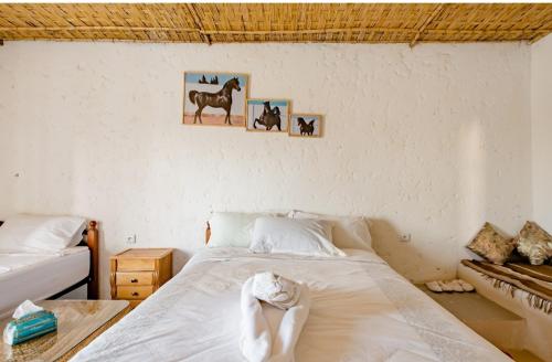 a bedroom with a bed and two pictures on the wall at Gîte équestre Balade plage petit déjeuner au bord de la piscine in Azemmour