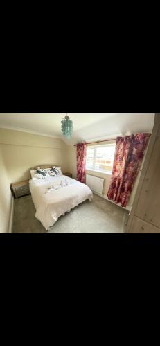 1 dormitorio con 2 camas y ventana en Comfy, cozy house with disabled access en St Ives