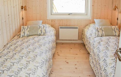 BjerregårdにあるAmazing Home In Hvide Sande With Saunaの窓付きの小さな部屋のベッド2台