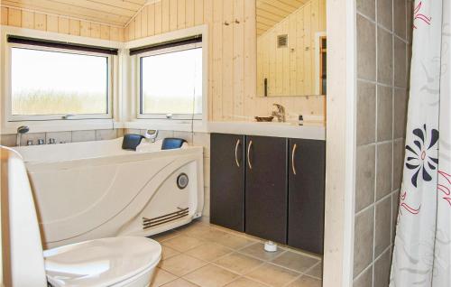 BjerregårdにあるAmazing Home In Hvide Sande With Saunaのバスルーム(バスタブ、トイレ、シンク付)