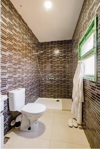 a bathroom with a toilet and a bath tub at Gîte équestre Balade plage petit déjeuner au bord de la piscine in Azemmour