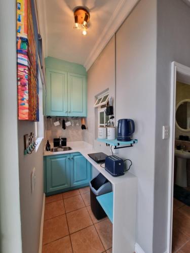 a kitchen with blue cabinets and a counter top at 7 on Cecilia - Private Studio Apartment with Solar Power in Ballito
