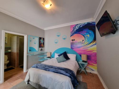 a bedroom with a bed and a painting on the wall at 7 on Cecilia - Private Studio Apartment with Solar Power in Ballito