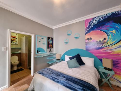 a bedroom with a large painting on the wall at 7 on Cecilia - Private Studio Apartment with Solar Power in Ballito