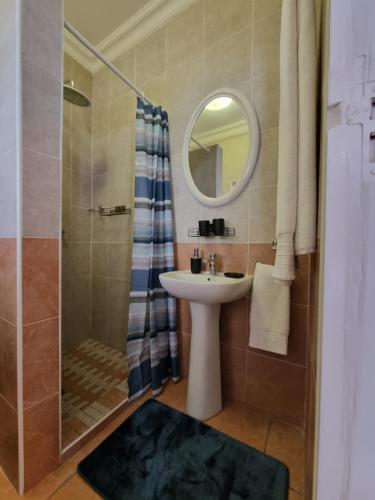 a bathroom with a sink and a shower with a mirror at 7 on Cecilia - Private Studio Apartment with Solar Power in Ballito