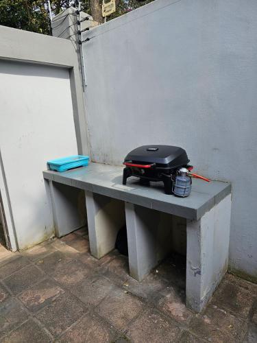 a black suitcase sitting on a bench next to a wall at 7 on Cecilia - Private Studio Apartment with Solar Power in Ballito