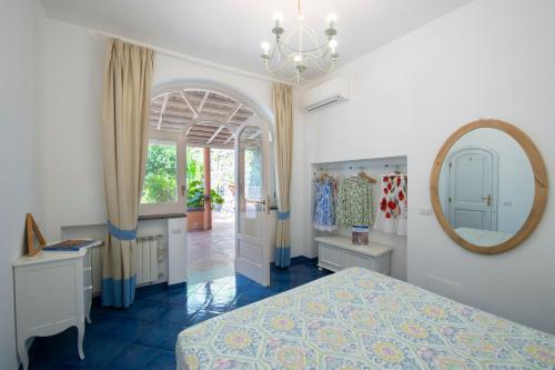 a bedroom with a bed and a mirror at Villa Ambra Positano in Positano