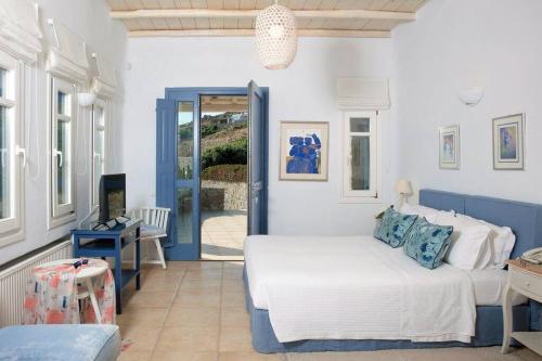 a bedroom with a bed and a door to a patio at Lia beach Estate in Mikonos