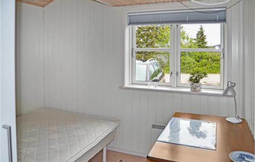 フレデリクスハウンにあるCozy Home In Frederikshavn With Kitchenのベンチと窓付きの小さな客室です。