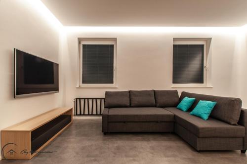 a living room with a couch and a flat screen tv at Cozy Little Apartments in Ig
