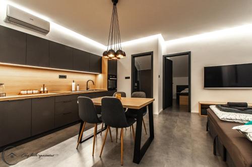 a kitchen and dining room with a table and chairs at Cozy Little Apartments in Ig