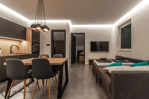 a living room with a bed and a dining room at Cozy Little Apartments in Ig