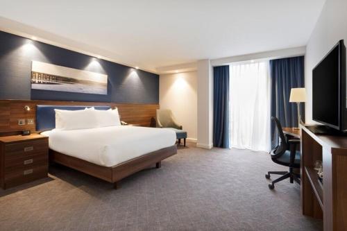 a hotel room with a bed and a desk and a television at Hampton by Hilton Dundee City Centre in Dundee