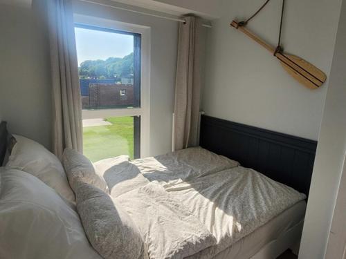 Bett in einem Zimmer mit Fenster in der Unterkunft APARTAMENT W TRZĘSACZU in Trzęsacz