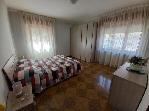 1 Schlafzimmer mit einem Bett und 2 Fenster mit Vorhängen in der Unterkunft Casa di Nzino in Guglionesi