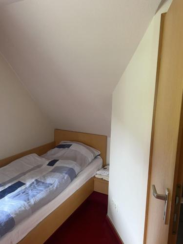 a small bedroom with a bed in a attic at Hotel Strand-Café in Roßbach
