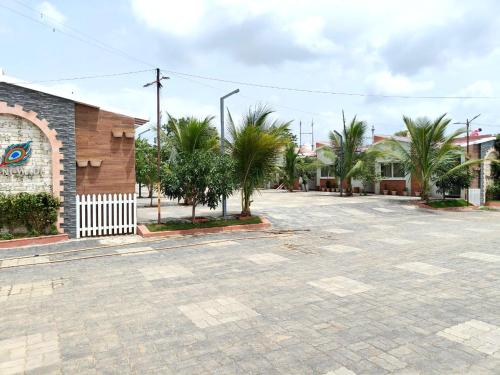 an empty parking lot with palm trees in front of a building at The Sky Imperial Sethji Ni Wadi in Indore