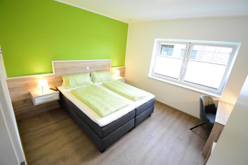Nord Koje 5 4 في نورديش: غرفة نوم بسرير وجدار أخضر