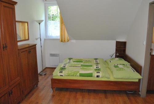 una camera da letto con letto con lenzuola verdi e finestra di Horské apartmány Jeseníky a Malá Morávka