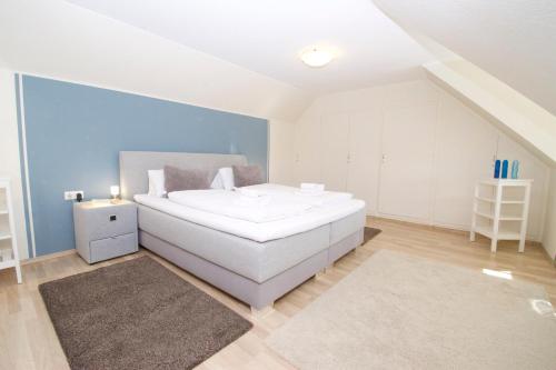 Sonnenwind am Norddeich في نورديش: غرفة نوم مع سرير أبيض كبير في غرفة