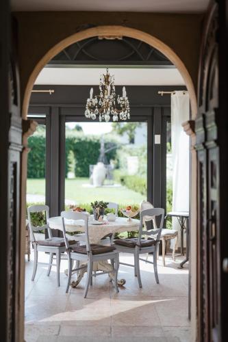 een eetkamer met een tafel, stoelen en een kroonluchter bij Madonna Villa Baietta in Verona