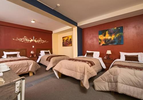 una habitación de hotel con 3 camas en una habitación en Hotel Andean Host Inn, en Cusco