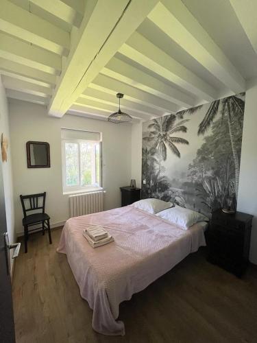 une chambre avec un grand lit avec un tableau au mur dans l'établissement Chez Ghislaine, à Saint-Appolinard
