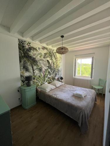 une chambre avec un grand lit et un lustre dans l'établissement Chez Ghislaine, à Saint-Appolinard