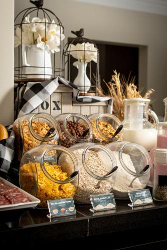 a table with many different types of food in glass containers at Hotel Kindermann in Caçador