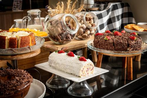 a display of cakes and other desserts on a table at Hotel Kindermann in Caçador