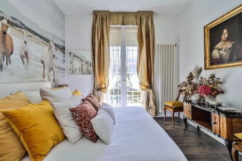1 dormitorio con cama con almohadas y ventana en Luxe Garden Apt for 2nr Bologna en Casalecchio di Reno