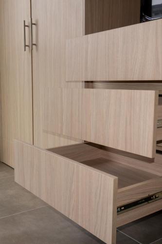 a cupboard with wooden drawers in a kitchen at confortable apartasuite en la playa in Gaira